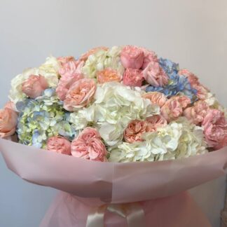 A bouquet of hydrangeas and a peony-shaped spray rose.